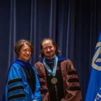 Provost Mili smiles for picture with faculty member